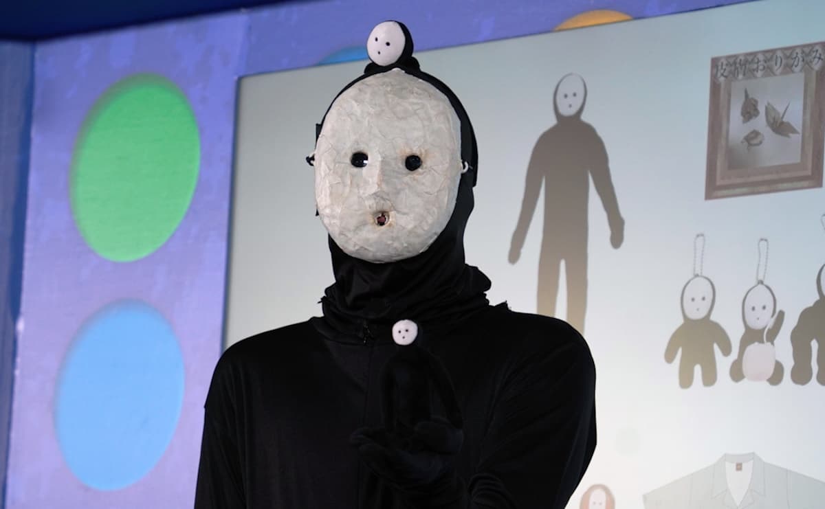 展覧会限定グッズを身につける雨穴さん